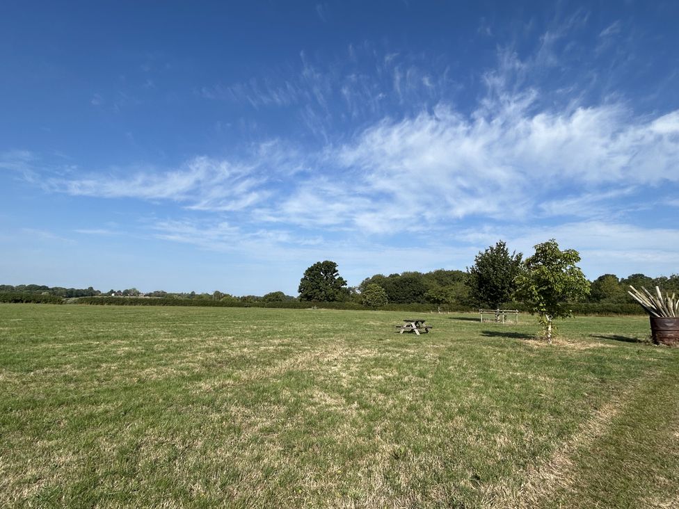 An outdoor scene with a picnic table and trees at Keepers Cottage in West Knoyle