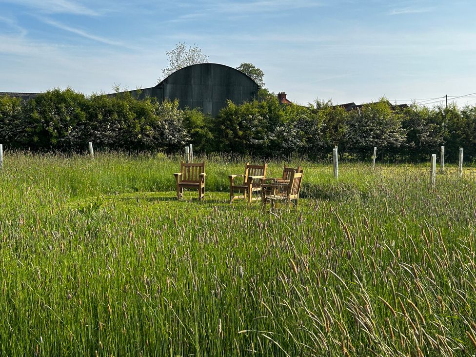 A garden with chairs and a table in the grass at Keepers Cottage in West Knoyle