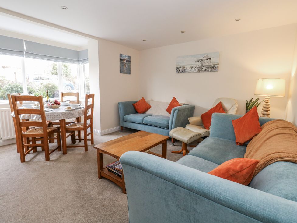 A living room with a sofa and dining area at Mayflower in Swanage