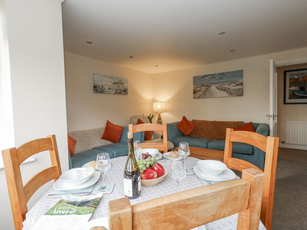 A living room with a dining table and sofa at Mayflower in Swanage