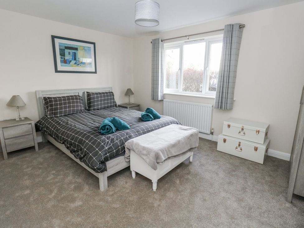 A bedroom featuring a bed, bedside table, and window at Mayflower in Swanage