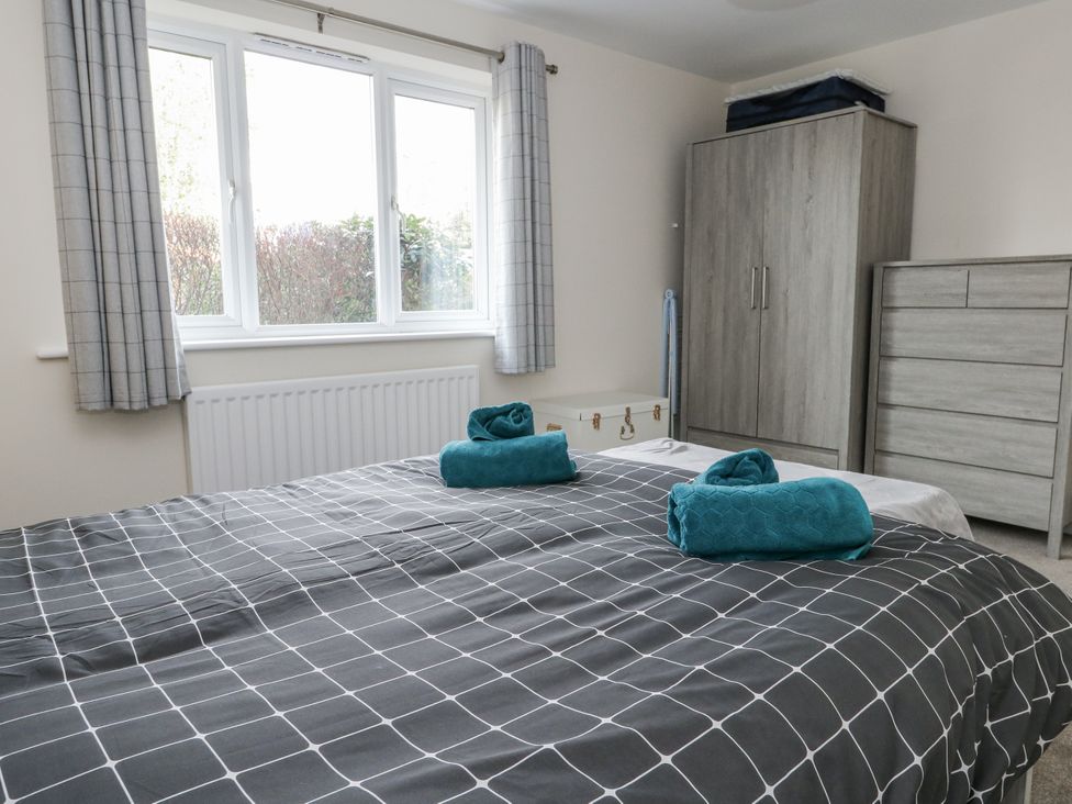 A bedroom with a bed and windows at Mayflower in Swanage