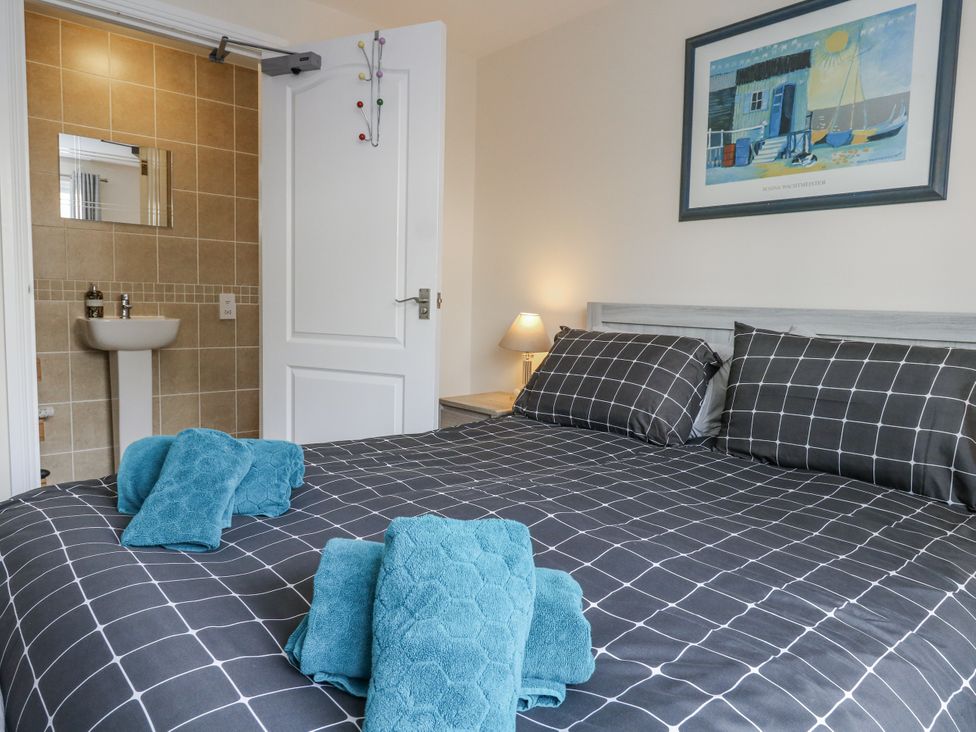 A bedroom with a bed and towels at Mayflower in Swanage