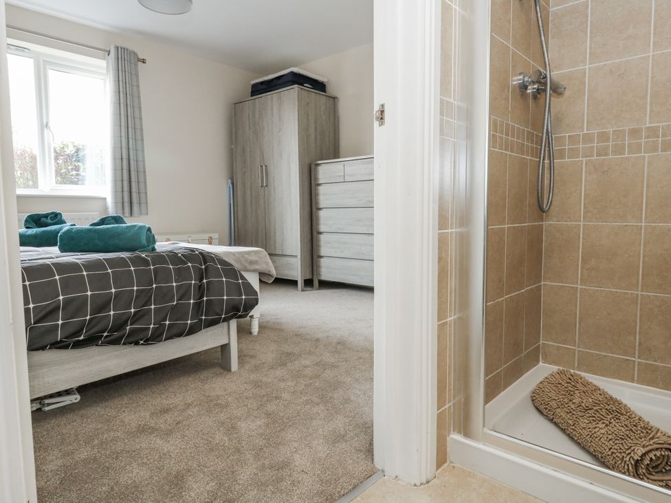 A bedroom with a bed and a shower at Mayflower in Swanage