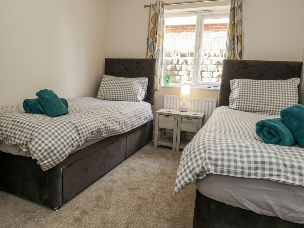 A bedroom with two beds and a table at Mayflower in Swanage