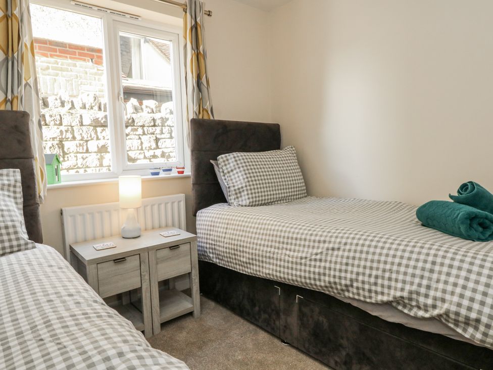 A bedroom with two single beds and a nightstand at Mayflower in Swanage