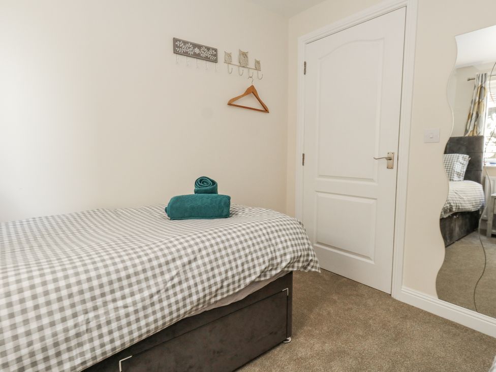 A bedroom with a single bed and towel at Mayflower in Swanage