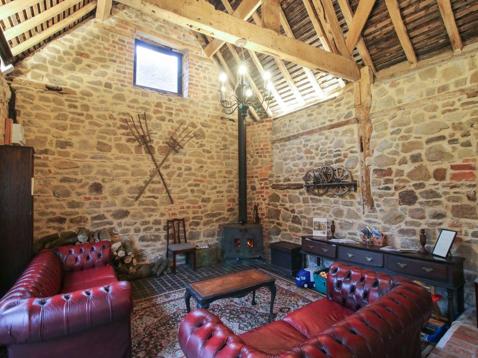 A snug with sofas and a wood stove at Turnip House in Cardington