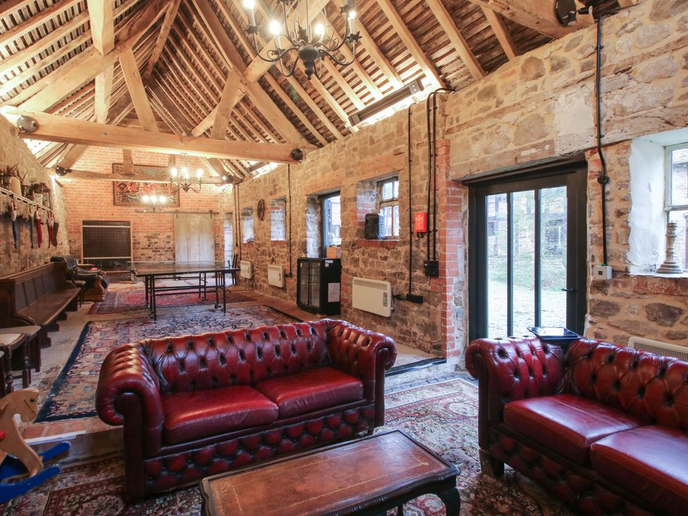 A living room with a table and sofas at Turnip House in Cardington