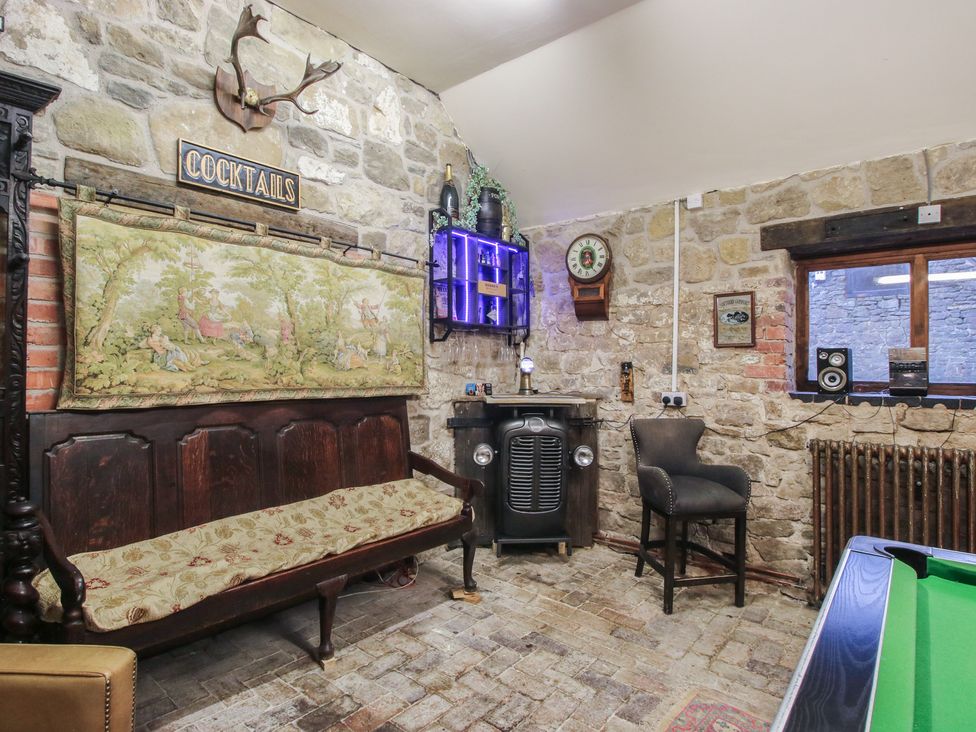 A snug with a bar area and sofa at Turnip House in Cardington