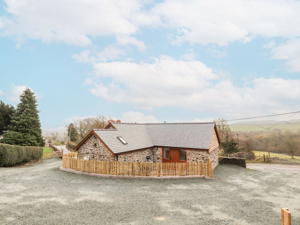 A house with a fence and driveway at Cut Moch, Plas Moelfre Hall Barns Moelfre near Llanrhaeadr-Ym-Mochnant