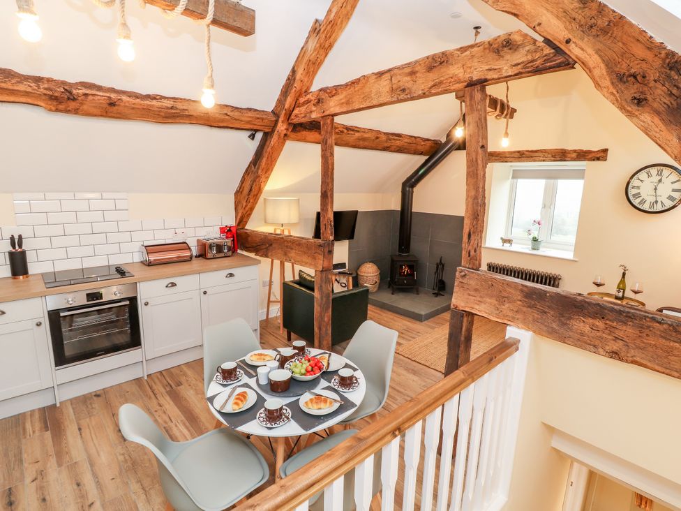 A kitchen with a table and chairs at Stabl, Plas Moelfre Hall Barns Moelfre near Llanrhaeadr-Ym-Mochnant