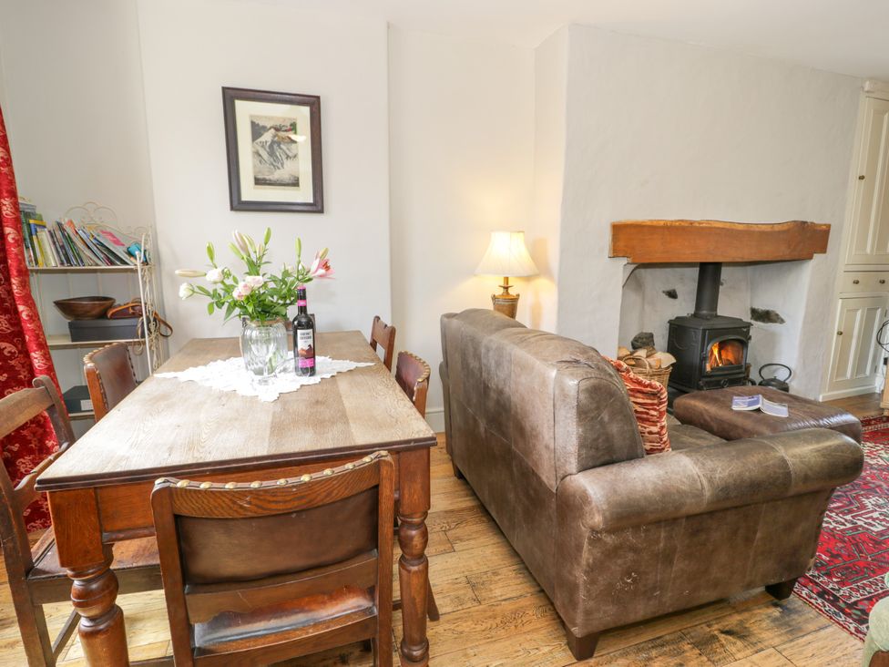A dining room with a table, chairs, and a sofa at Sygun View in Beddgelert