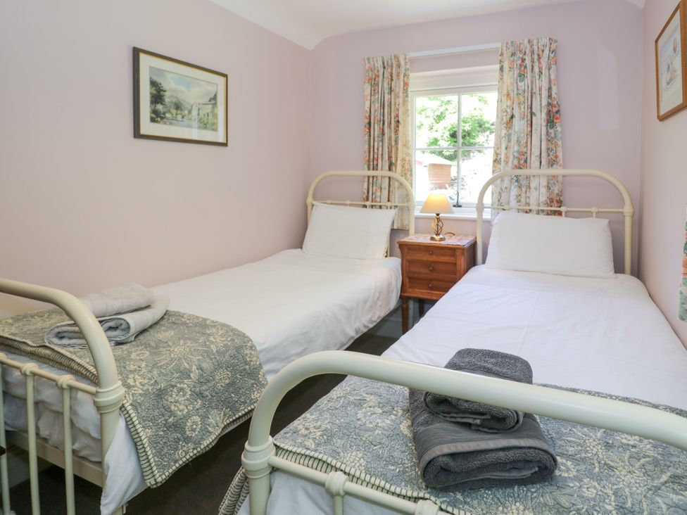 A bedroom with two single beds and a bedside table at Sygun View in Beddgelert