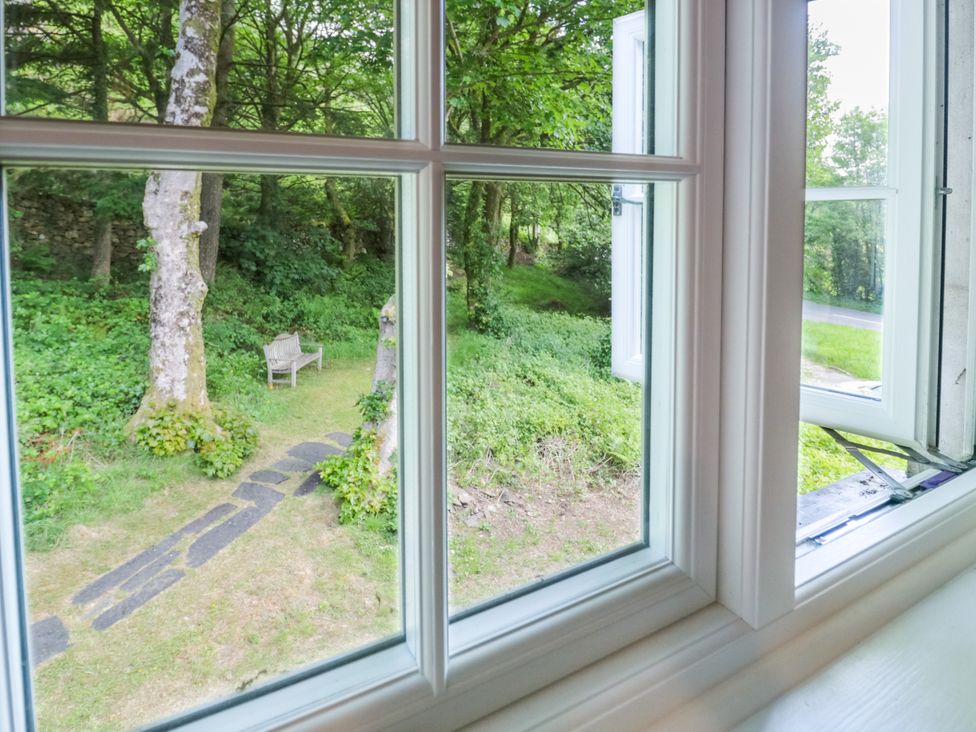 A view from a window showing a garden with a bench at Sygun View in Beddgelert