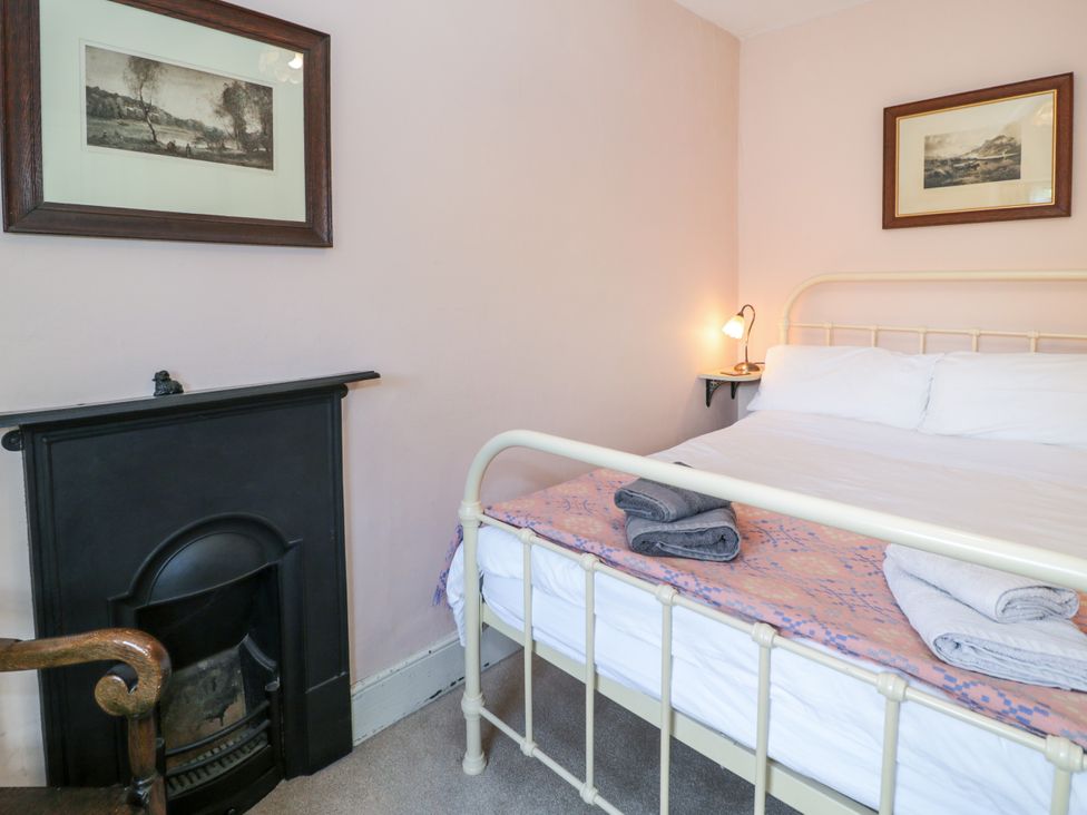 A bedroom with a bed and fireplace at Sygun View in Beddgelert
