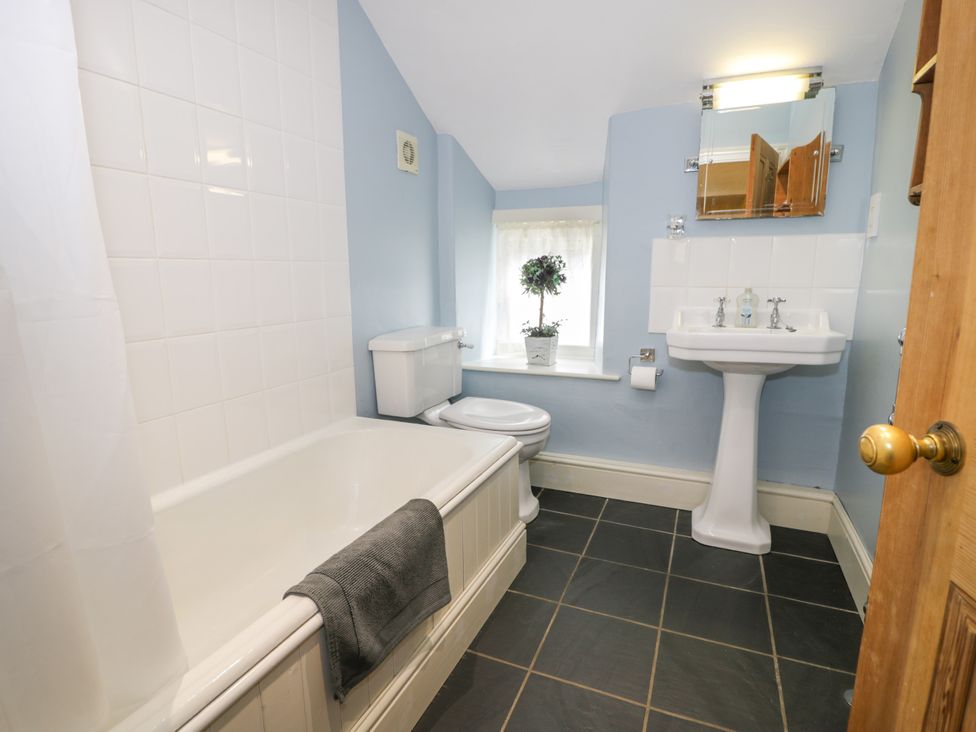A bathroom with a bathtub, toilet, and sink at Sygun View in Beddgelert