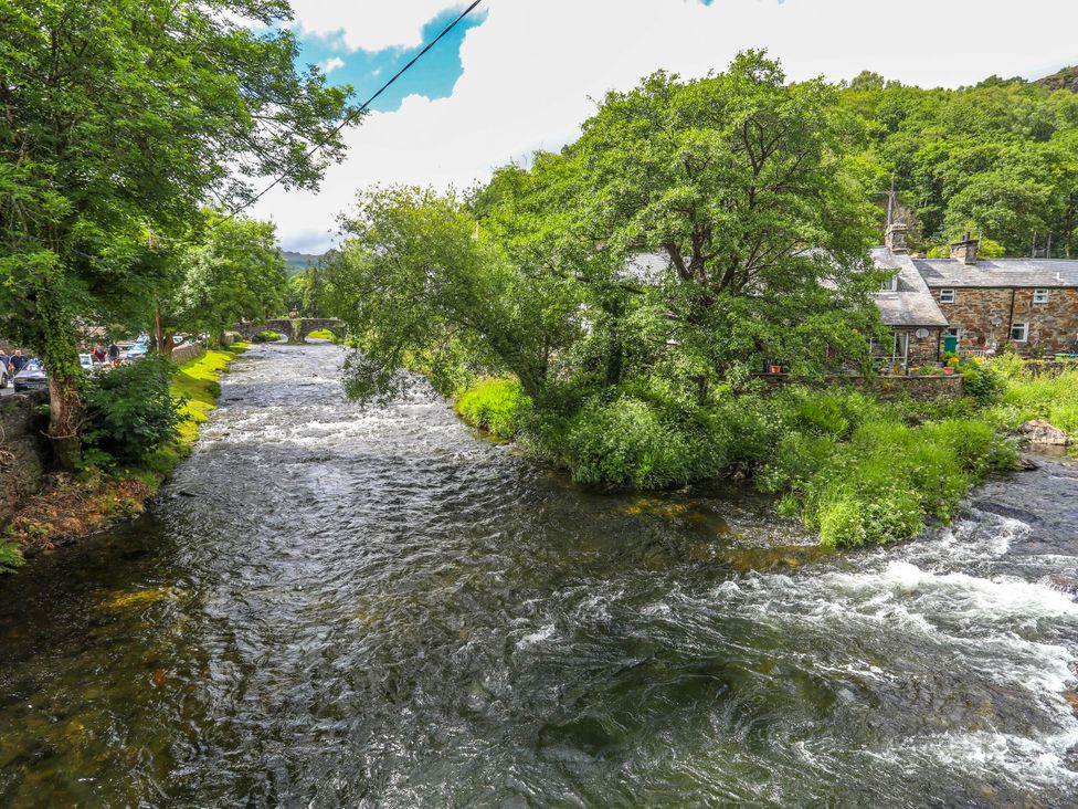 A river with trees and a bridge near a house at Sygun View in Beddgelert