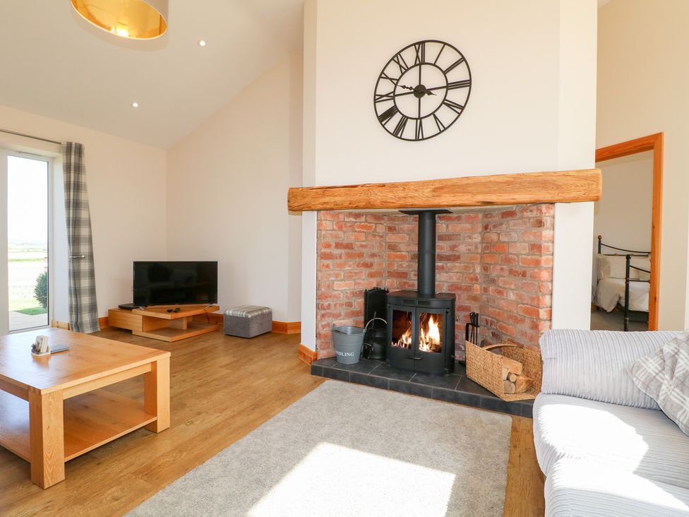 A living room with a fireplace and tv at Mandarin Cottage in Melton Mowbray