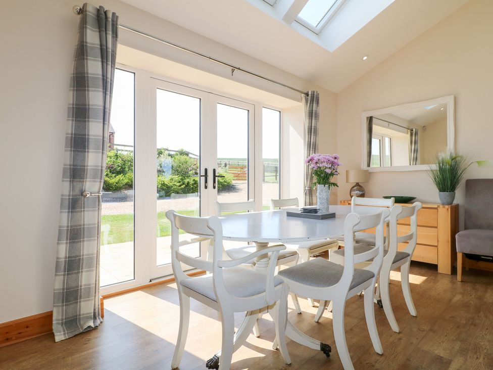 A dining room with a table and chairs at Mandarin Cottage in Melton Mowbray