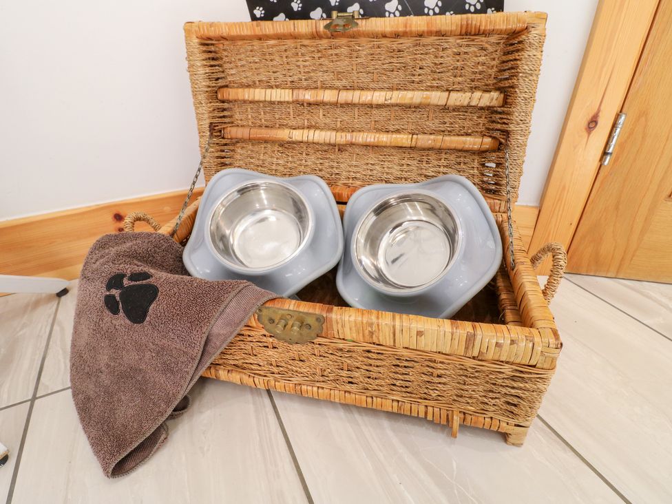 A basket with bowls and a towel at Mandarin Cottage in Melton Mowbray