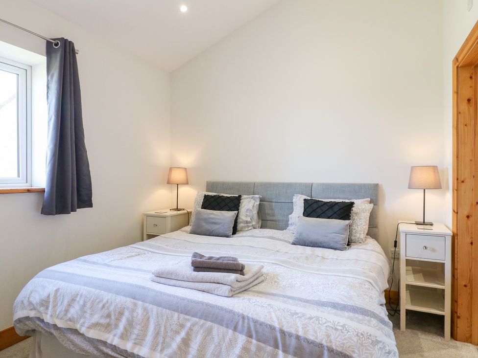 A bedroom with a bed and nightstand at Mandarin Cottage in Melton Mowbray