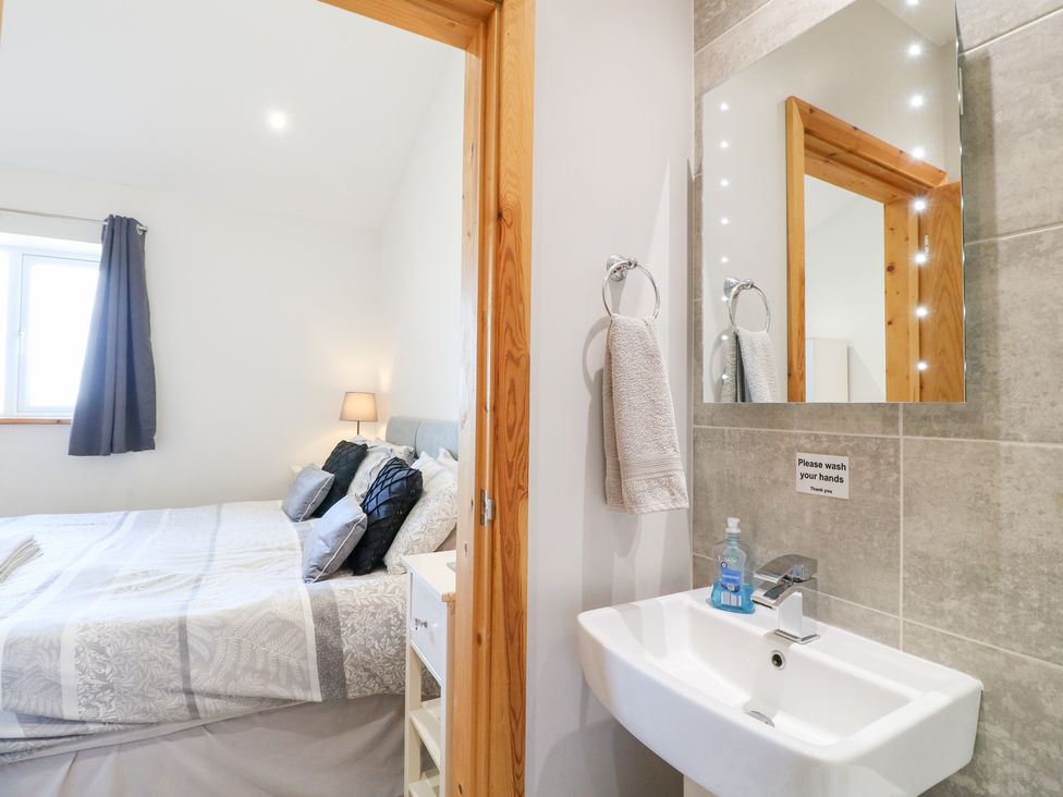 A bedroom with bed and wash area at Mandarin Cottage in Melton Mowbray