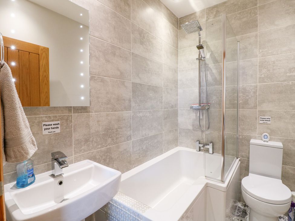 A bathroom with a sink and bathtub at Mandarin Cottage in Melton Mowbray