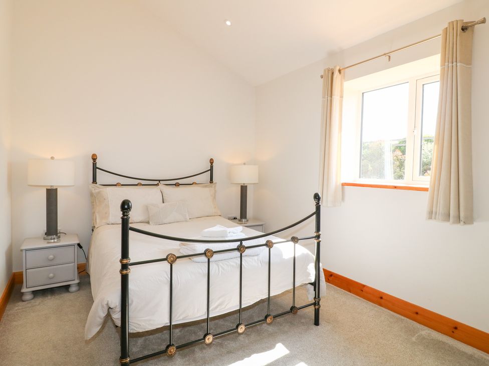 A bedroom with a bed and bedside tables at Mandarin Cottage Melton Mowbray