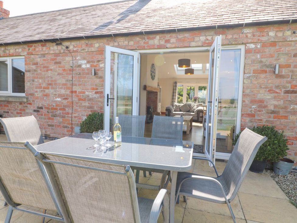 An outdoor seating area with a table and chairs at Mandarin Cottage in Melton Mowbray