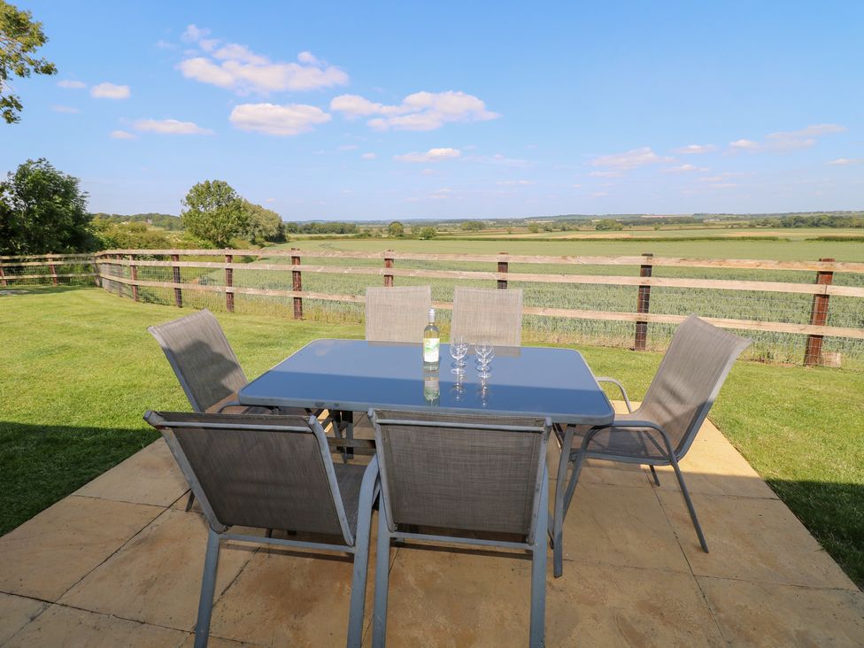 An outdoor dining area with a table and chairs at Mandarin Cottage in Melton Mowbray