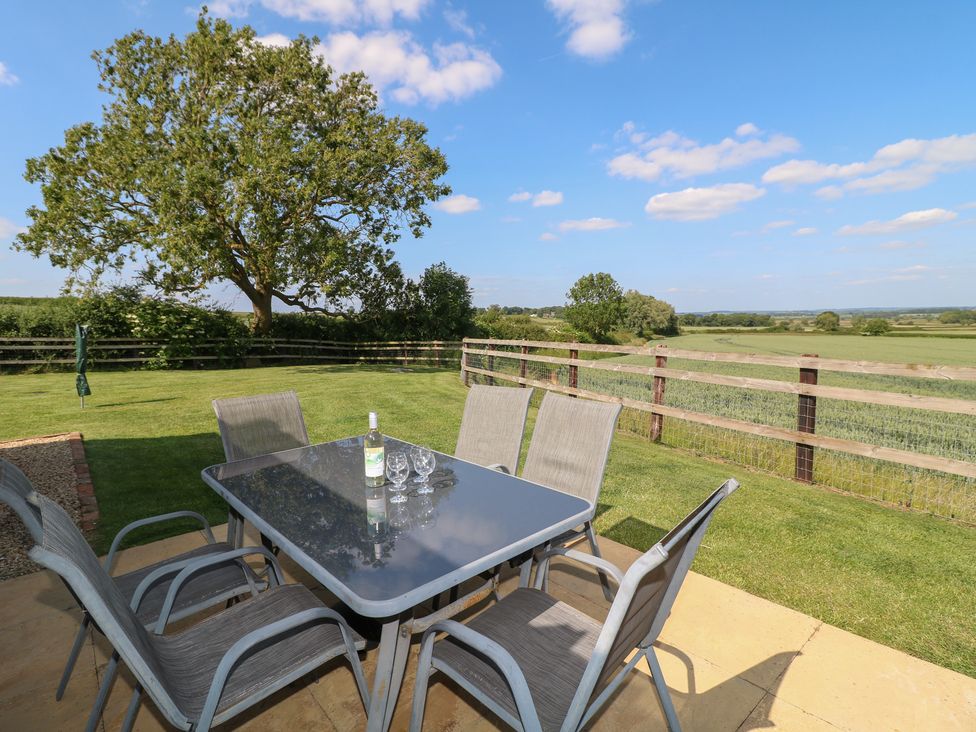 An outdoor dining area with table and chairs at Mandarin Cottage Melton Mowbray