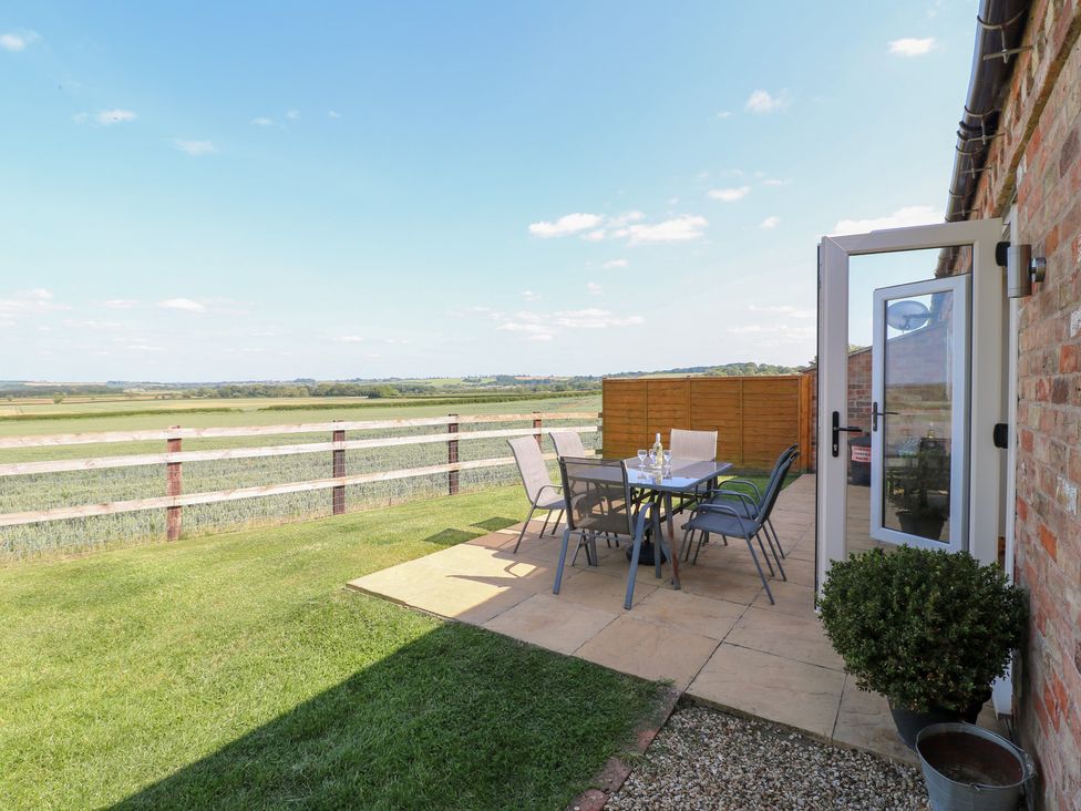 An outdoor dining area with a table and chairs at Mandarin Cottage Melton Mowbray