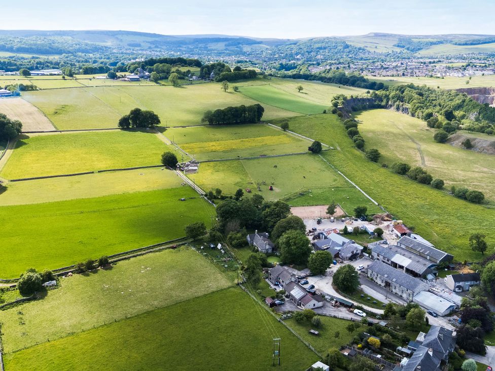An aerial view of a farm with fields and buildings at The Loft in Buxton