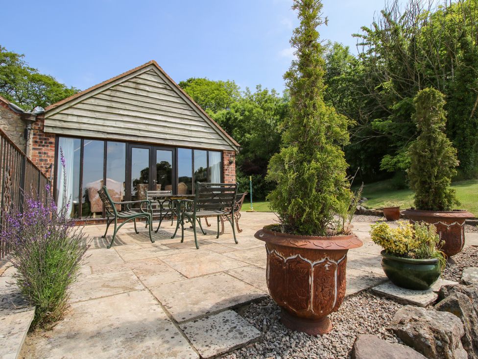 A garden with furniture and planters at Corn House in Cardington