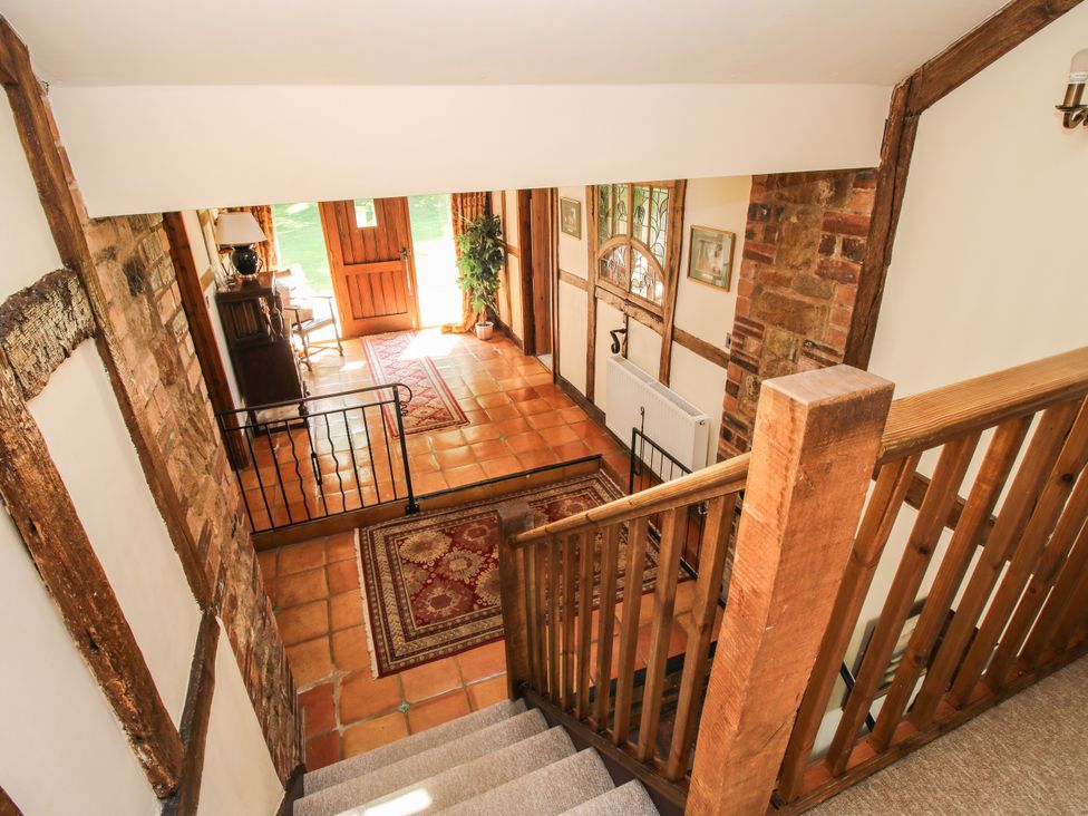 A staircase leading to a hallway with a door at Corn House in Cardington