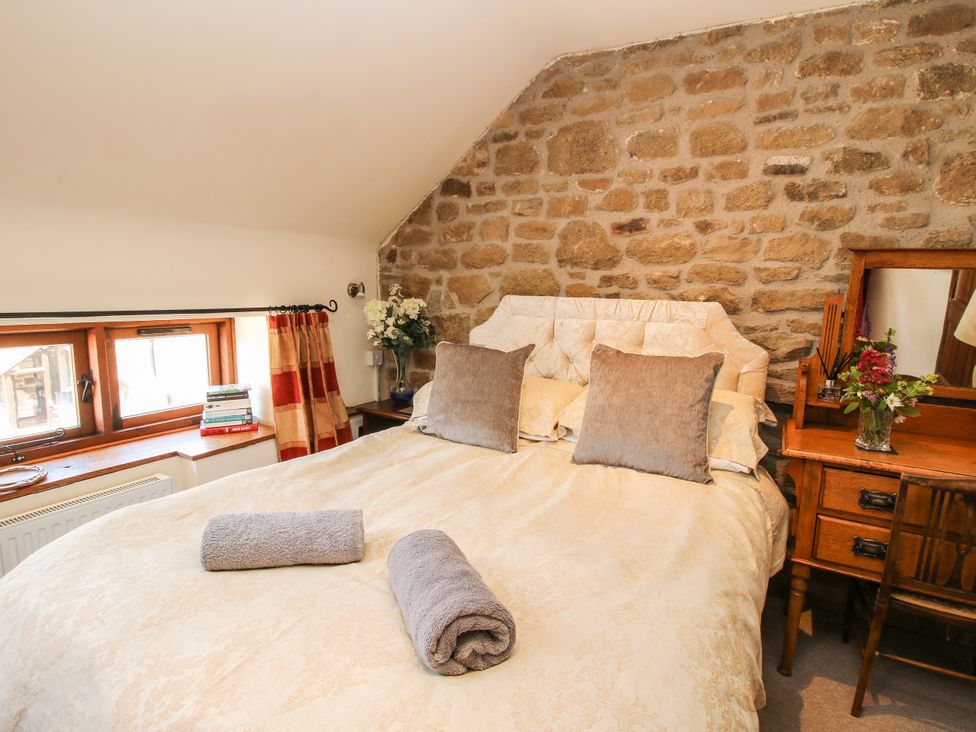 A bedroom with a bed and bedside table at Corn House in Cardington