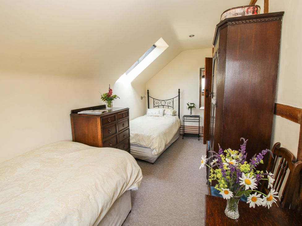 A bedroom with two beds and a dresser at Corn House in Cardington