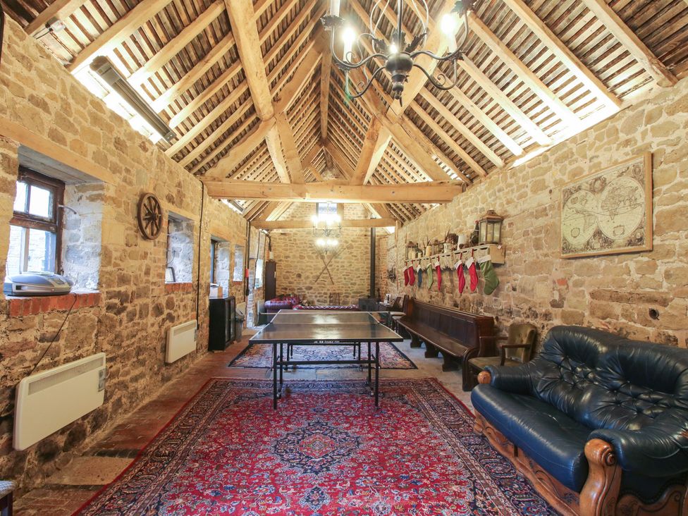 A recreation room with a ping pong table and a sofa at Corn House in Cardington