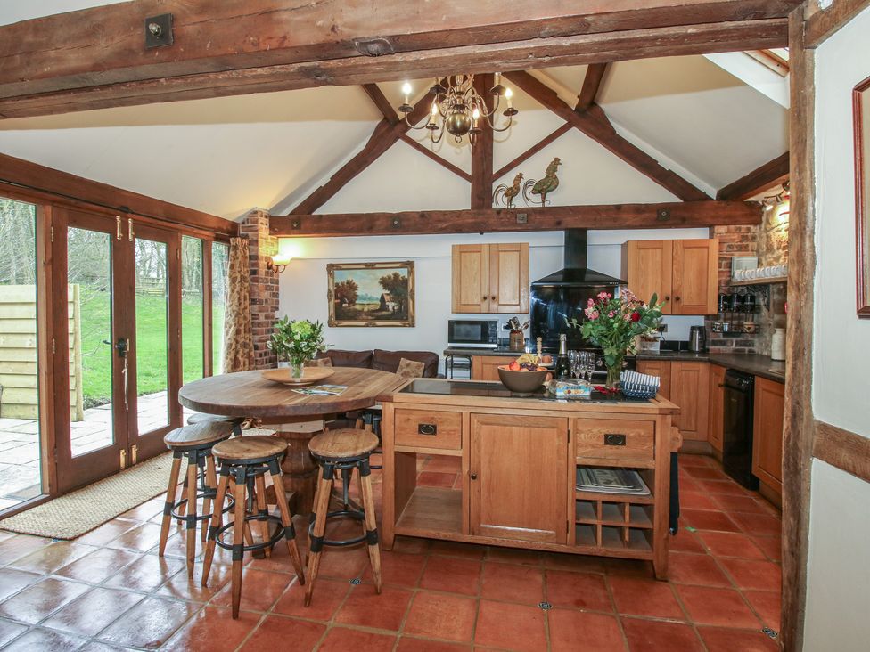 A kitchen with wooden furniture and appliances at Corn House in Cardington