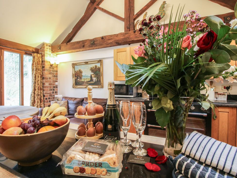A kitchen with a fruit bowl and champagne on the counter at Corn House in Cardington
