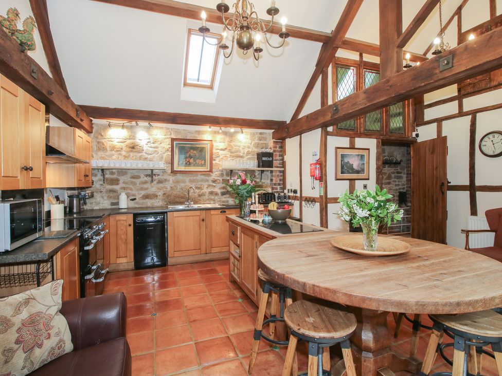 A kitchen with wooden cabinets and an island at Corn House in Cardington
