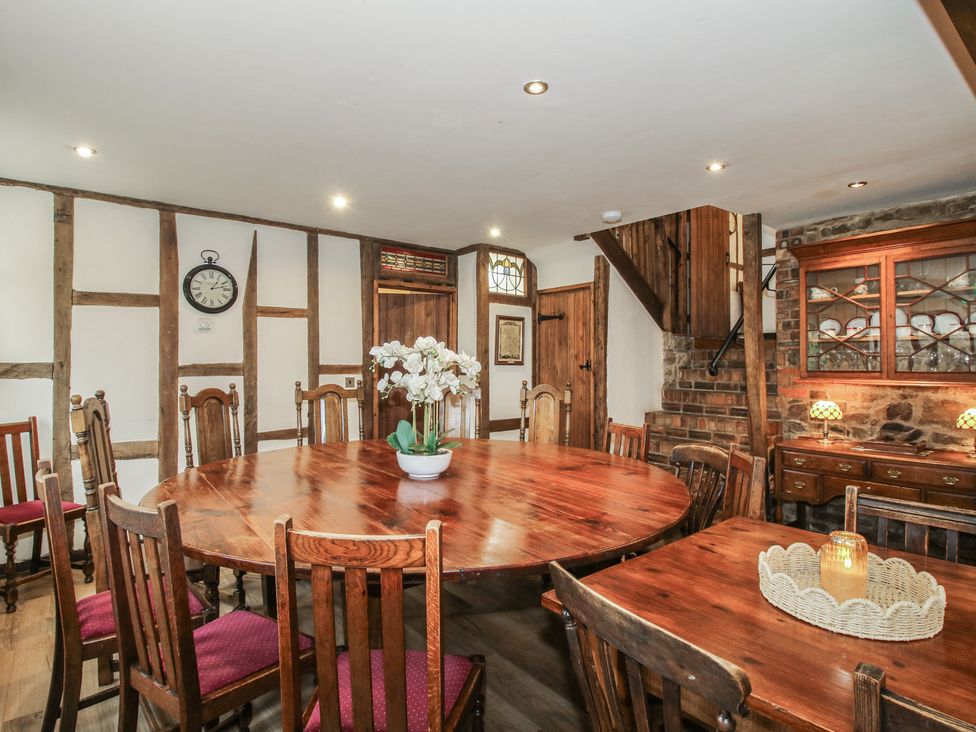 A dining room with a round wooden table at Corn House in Cardington