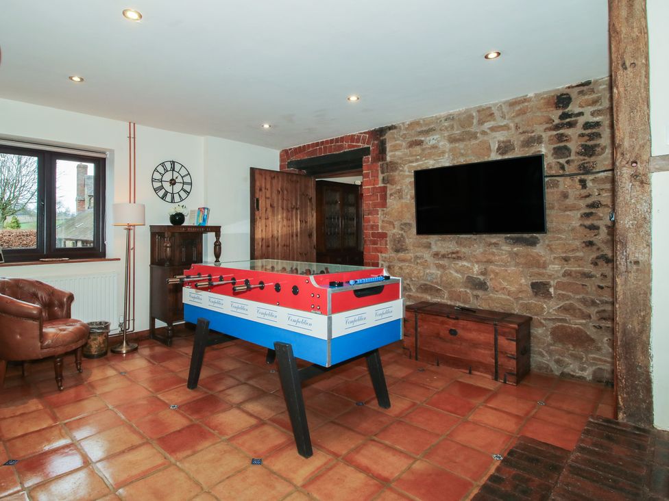 A game room with a foosball table and a television at Corn House in Cardington