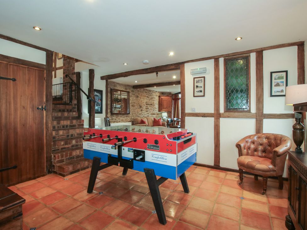 A snug with a foosball table and wooden door at Corn House in Cardington