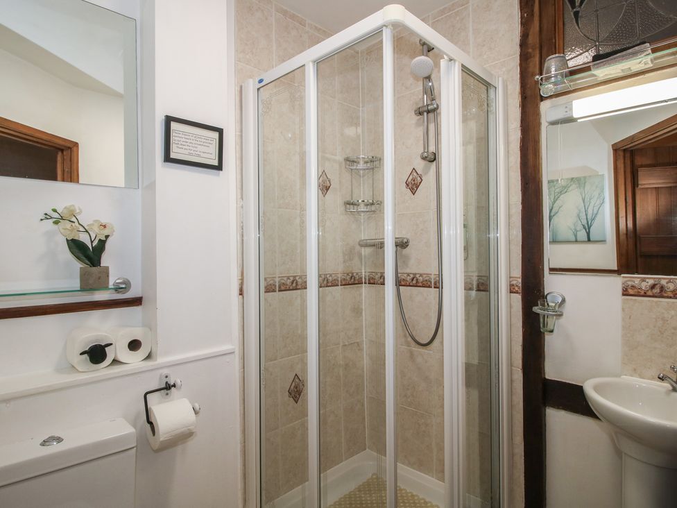 A bathroom with a shower unit, toilet and sink at Corn House in Cardington