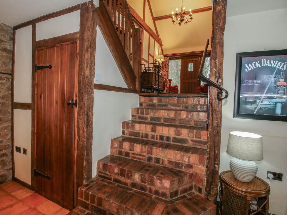 A staircase with a wooden door and lamp in a hallway at Corn House in Cardington