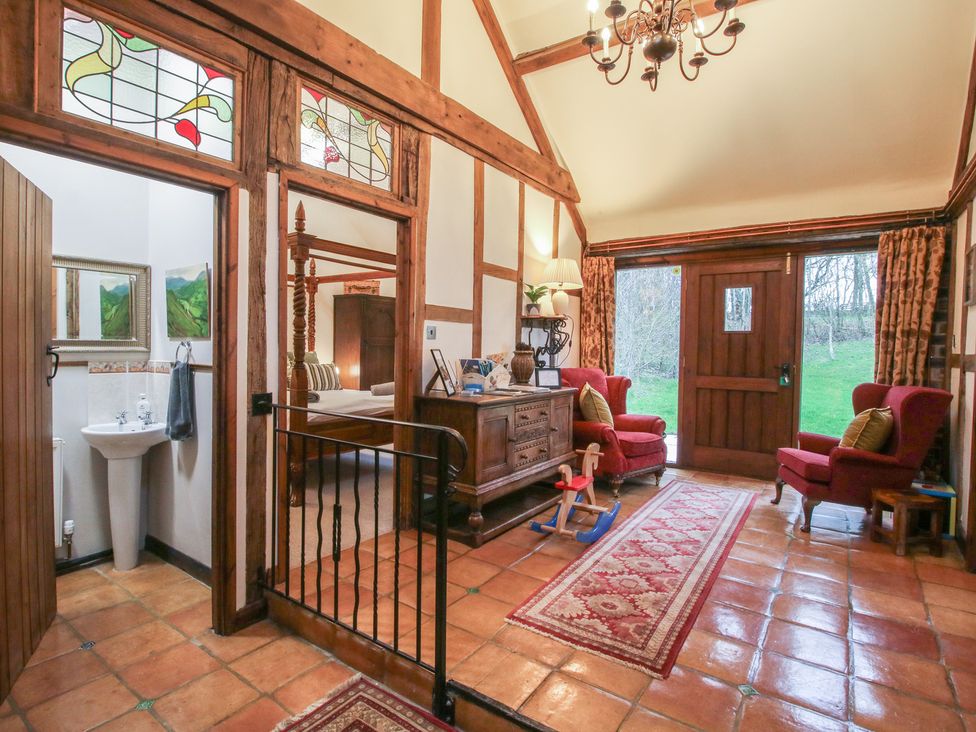 An entrance hall with a sink and wooden furniture at Corn House in Cardington