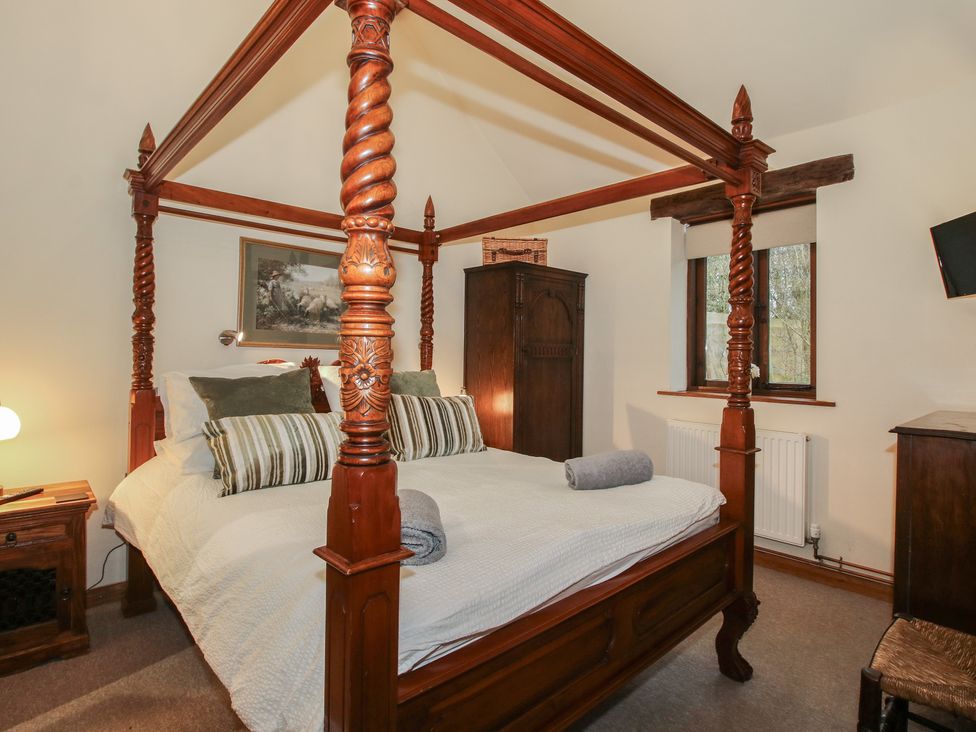 A bedroom with a four-poster bed and wardrobe at Corn House in Cardington