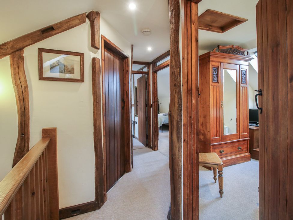 A hallway with wooden beams and a wardrobe at Corn House in Cardington